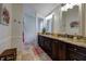 Beautiful bathroom with tile floor, granite countertop, undermount sinks, and decorative mirrors at 3241 Downs Cove Rd, Windermere, FL 34786
