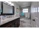 Well-lit bathroom with granite-topped vanity, tub with shower, and tiled floor at 3241 Downs Cove Rd, Windermere, FL 34786