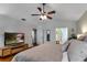 This stylish bedroom has wood floor, ceiling fan, TV, and view of ensuite bathroom at 3241 Downs Cove Rd, Windermere, FL 34786