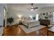Airy main bedroom boasts high ceilings, wood floors, plants, large bed, dresser, and tasteful decor at 3241 Downs Cove Rd, Windermere, FL 34786