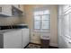 Functional laundry room with washer, dryer, ample cabinet storage, and a bright window at 3241 Downs Cove Rd, Windermere, FL 34786
