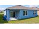 A covered patio with outdoor seating provides a great view of the landscaped backyard at 3354 Aruba Way, Haines City, FL 33844