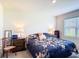 Bedroom featuring floral bedding, side tables with lamps, and a window providing natural light for a serene atmosphere at 3354 Aruba Way, Haines City, FL 33844