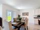 Bright dining area with a wooden table, comfortable upholstered chairs, and sliding glass door leading to the backyard at 3354 Aruba Way, Haines City, FL 33844