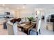 Bright dining area featuring a modern kitchen, a wooden dining table with seating for six, and tile flooring at 3354 Aruba Way, Haines City, FL 33844