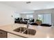 Open-concept kitchen island with sink and view into adjacent dining and living room at 3354 Aruba Way, Haines City, FL 33844