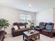 Comfortable living room with reclining leather sofas, a wooden coffee table, and a bright window at 3354 Aruba Way, Haines City, FL 33844