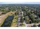A sprawling aerial view showcases a neighborhood with lush greenery and picturesque homes around a scenic pond at 3840 Caledonia Ave, Apopka, FL 32712