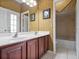 Well-lit bathroom with double vanity, framed mirrors, and a separate shower/tub area at 3840 Caledonia Ave, Apopka, FL 32712