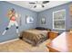 Cozy bedroom featuring a ceiling fan and neutral-toned carpet with a large poster on the wall at 3840 Caledonia Ave, Apopka, FL 32712