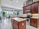 Well-lit kitchen featuring wooden cabinets, stainless steel appliances, and an island, creating a modern and functional space at 3840 Caledonia Ave, Apopka, FL 32712