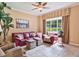Cozy living room with a red leather sofa set, a ceiling fan, and a large window for ample natural light at 3840 Caledonia Ave, Apopka, FL 32712