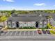Condominium building featuring a well-kept gray exterior and ample parking with mature landscaping at 4160 Pershing Pointe Pl # 4, Orlando, FL 32822