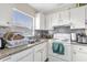 Functional kitchen features white cabinets, granite counters, and modern appliances for efficient cooking at 4160 Pershing Pointe Pl # 4, Orlando, FL 32822