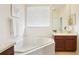 Bright bathroom features a soaking tub with white tile surround and a vanity with cherry wood cabinets at 4301 Heirloom Rose Pl, Oviedo, FL 32766