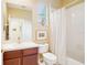 Bathroom features a vanity with cherry wood cabinets, a toilet, and a bathtub with a shower curtain at 4301 Heirloom Rose Pl, Oviedo, FL 32766
