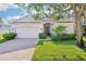 Charming single-story home featuring a well-manicured lawn, brick driveway, and lush landscaping at 4301 Heirloom Rose Pl, Oviedo, FL 32766