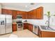 Modern kitchen with stainless steel appliances, cherry cabinets, and ample counter space for meal preparation at 4301 Heirloom Rose Pl, Oviedo, FL 32766
