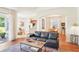 Open-concept living space with hardwood floors, a cozy seating area, and views of the kitchen and dining room at 4301 Heirloom Rose Pl, Oviedo, FL 32766