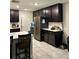 Spacious kitchen featuring dark cabinets, stainless steel appliances, and a large island with seating at 4427 Blackbird St, Kissimmee, FL 34746