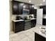 Modern kitchen featuring dark wood cabinets, stainless steel appliances, and a pantry at 4427 Blackbird St, Kissimmee, FL 34746