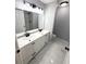 Bathroom with double sink vanity, black hardware, and marble-look tile flooring at 4919 Nw 61St Ct, Ocala, FL 34482