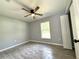 This gray bedroom features wood look tile floors, ceiling fan, and a window for natural light at 4919 Nw 61St Ct, Ocala, FL 34482