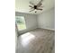 This bedroom offers updated ceiling fan, wood look tile floors, neutral gray paint, and a window at 4919 Nw 61St Ct, Ocala, FL 34482