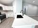 An open kitchen with white cabinetry, sleek black hardware, and a large island with a sink at 4919 Nw 61St Ct, Ocala, FL 34482