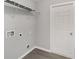 Clean laundry room with gray flooring, shelving, and white door at 4919 Nw 61St Ct, Ocala, FL 34482