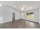 Well-lit living room featuring gray floors, a ceiling fan, and a view of the backyard at 4919 Nw 61St Ct, Ocala, FL 34482