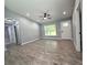 An open-concept living room with wood-look tile floors, a ceiling fan, and plenty of natural light at 4919 Nw 61St Ct, Ocala, FL 34482