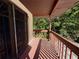 View of the balcony with wooden railings, an iron gate, and lush foliage in the background at 4981 Lake Cecile Dr, Kissimmee, FL 34746