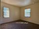 Sunny bedroom features neutral walls, carpet floors, and natural light through windows at 4981 Lake Cecile Dr, Kissimmee, FL 34746