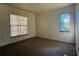 A simple bedroom showcasing neutral walls, carpet floors, and natural light through two windows at 4981 Lake Cecile Dr, Kissimmee, FL 34746