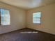 Bright bedroom with neutral paint, carpet flooring, and natural light from two windows at 4981 Lake Cecile Dr, Kissimmee, FL 34746