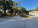 Long driveway surrounded by mature trees, leading to a garage and workshop on a sunny day at 4981 Lake Cecile Dr, Kissimmee, FL 34746