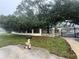 A stone and wrought iron gate with mature trees and landscaping providing privacy in this gated property at 4981 Lake Cecile Dr, Kissimmee, FL 34746