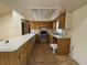 Kitchen featuring wooden cabinetry, appliances, and a breakfast bar at 4981 Lake Cecile Dr, Kissimmee, FL 34746