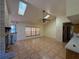 Bright living room featuring a brick fireplace, vaulted ceilings, skylights, large windows, and tile floors at 4981 Lake Cecile Dr, Kissimmee, FL 34746