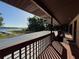 Wide covered porch with wood flooring and railings, offering tranquil views of the lake and docks at 4981 Lake Cecile Dr, Kissimmee, FL 34746