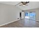 Bright bedroom with light gray walls, a ceiling fan, wood-look floors and sliding doors to the pool area at 5039 Jamaica # 10, Orlando, FL 32808