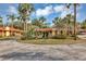 Well-manicured community with lush landscaping, mature trees, and circular driveway at 5039 Jamaica # 10, Orlando, FL 32808