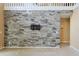 Living room features a gray stone accent wall with mount for TV, and neutral carpet at 508 Key Ct, Orlando, FL 32828