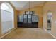 Carpeted living room featuring a built-in cabinet and a large arched window for ample light at 508 Key Ct, Orlando, FL 32828