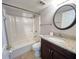 Clean bathroom featuring a tub-shower combo and granite vanity top with a round mirror at 51 Windtree Ln # 101, Winter Garden, FL 34787