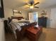 Cozy main bedroom with a bed and dressers, and ceiling fan with ensuite access to the bathroom at 51 Windtree Ln # 101, Winter Garden, FL 34787