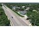 An aerial view highlights a modern home along a bustling street, surrounded by lush landscaping and nearby residences at 5852 Medinah Way, Orlando, FL 32819
