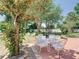 Charming backyard patio with a glass top table, white chairs, and mature trees at 5852 Medinah Way, Orlando, FL 32819