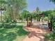 Lush backyard featuring a pergola, seating area, and well-maintained lawn at 5852 Medinah Way, Orlando, FL 32819